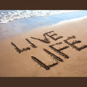 Plage avec une écriture dans le sable "Live Life"